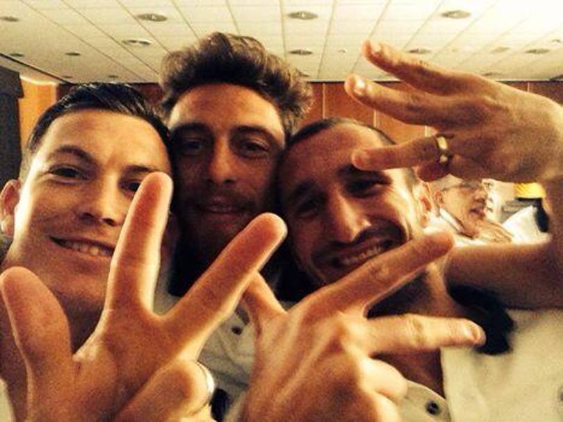 Lichtsteiner, Marchisio e Chiellini: le dita indicano che sono tre gli scudetti vinti di fila